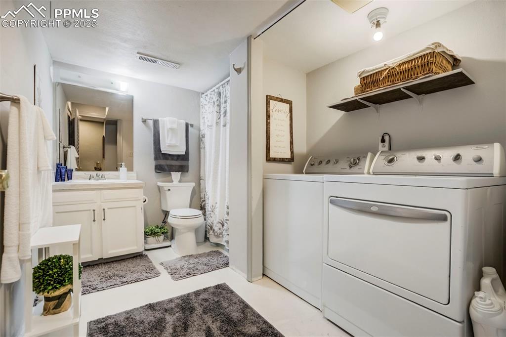 Image 25 of 31: Full bathroom with washer and clothes dryer and vanity