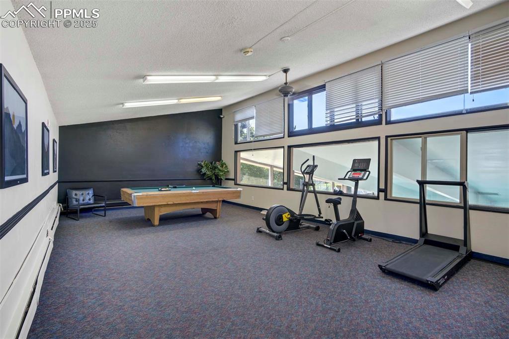 Image 29 of 31: Exercise room featuring a textured ceiling, billiards table, lofted ceiling