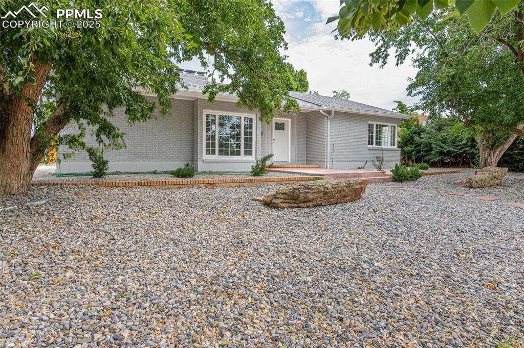 Caption: Ranch-style house featuring brick siding and roof with shingles