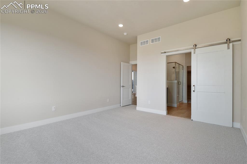 Image 14 of 35: Barn door leading to en-suite bath