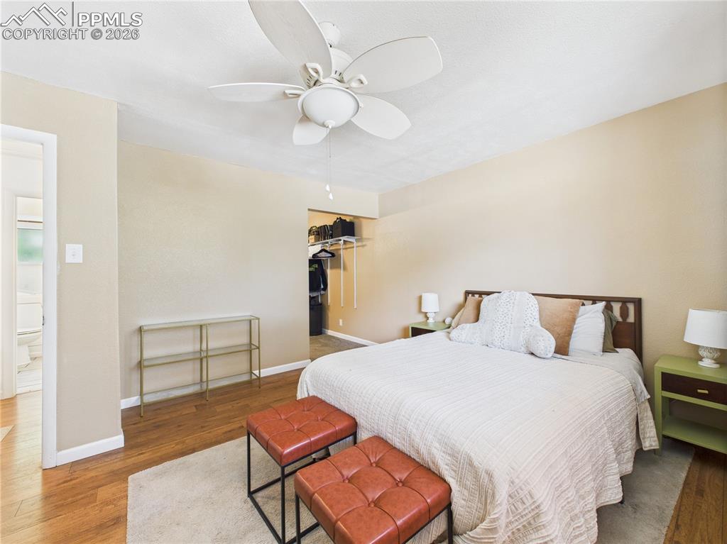 Image 15 of 39: Bedroom featuring wood finished floors, a ceiling fan, and a walk in closet
