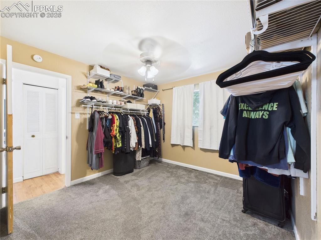 Image 17 of 39: Walk in closet featuring light colored carpet and ceiling fan