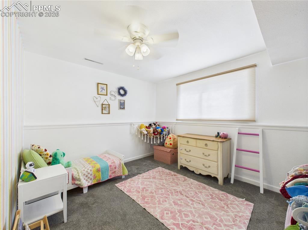 Image 20 of 39: Bedroom featuring a ceiling fan and dark carpet