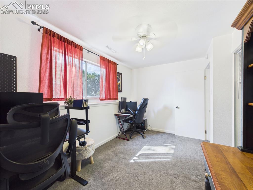 Image 25 of 39: Office area featuring light colored carpet and ceiling fan