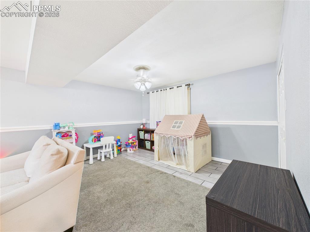 Image 29 of 39: Playroom with light carpet, ceiling fan, and light tile patterned flooring