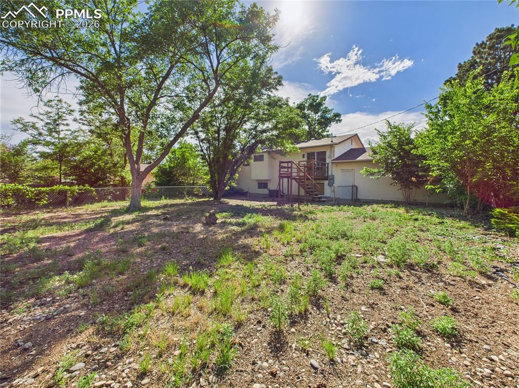Image 33 of 39: Fenced yard featuring stairs and a deck