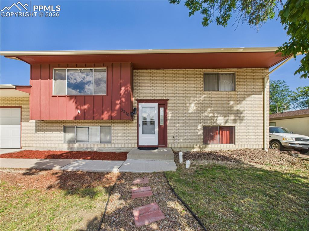 Image 38 of 39: Bi-level home featuring a front yard and a garage