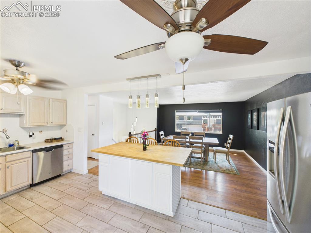 Image 7 of 39: Kitchen with stainless steel appliances, a ceiling fan, butcher block count