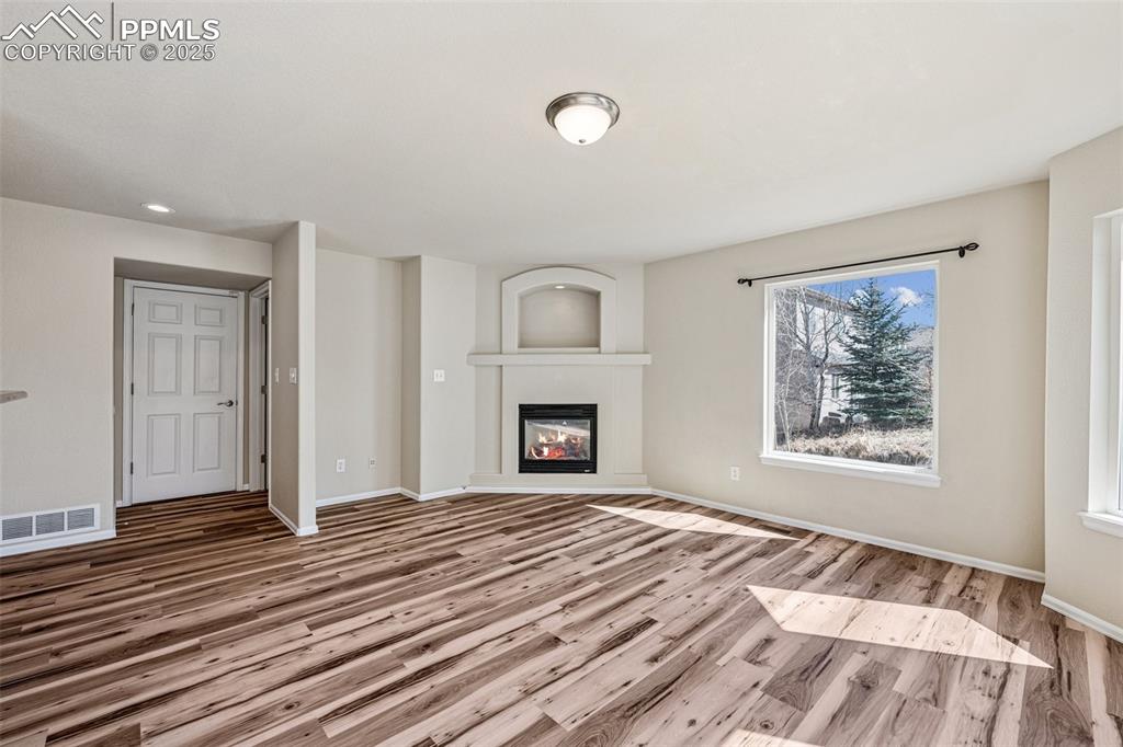 Image 22 of 43: Unfurnished living room featuring visible vents, baseboards, a glass covere