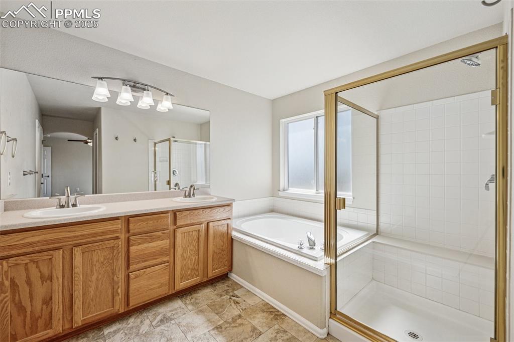 Image 29 of 43: Primary Bathroom featuring a bath, a shower stall, double vanity, and a sin