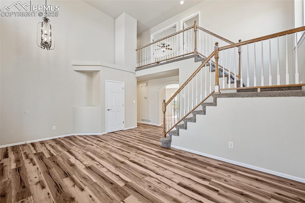Image 3 of 43: Foyer with visible vents, a notable chandelier, wood finished floors, arche