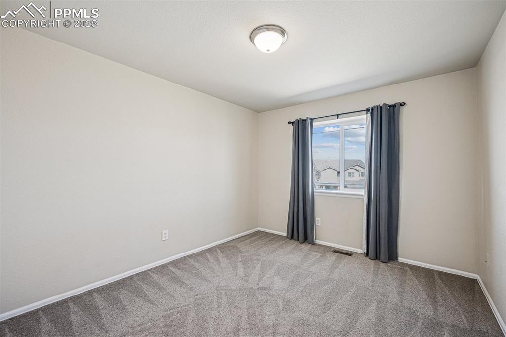 Image 32 of 43: Spare room featuring visible vents, carpet flooring, and baseboards