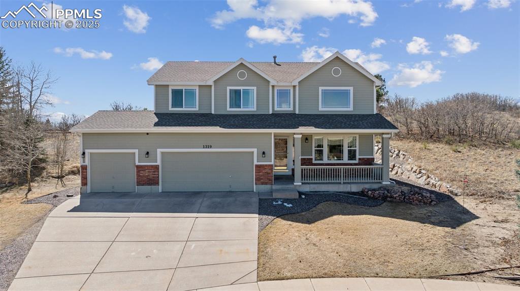 Image 6 of 43: View of front of house with roof with shingles, a porch, concrete driveway,