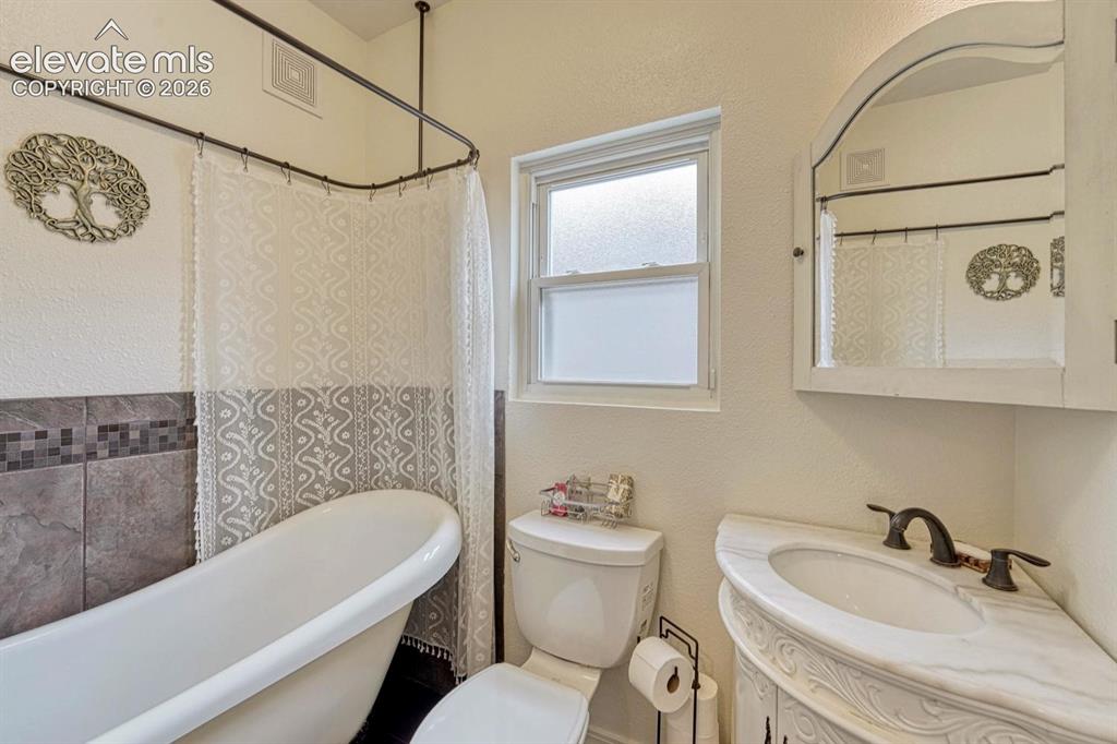 Image 17 of 50: Full bathroom on the main level includes a beautiful clawfoot tub!