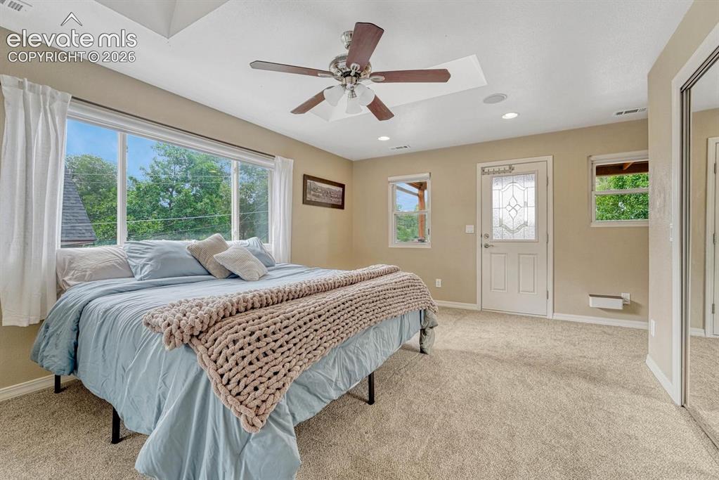 Image 20 of 50: Primary bedroom features skylights, balcony overlooking the back yard, and