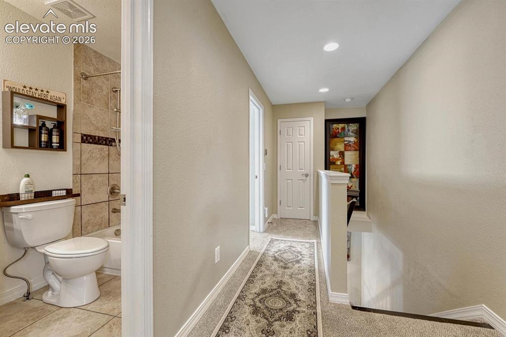 Image 28 of 50: Full bathroom on the upper level serves the secondary bedrooms