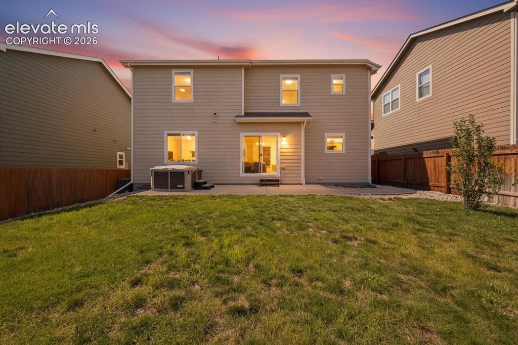 Image 18 of 20: Fenced backyard, and a hot tub, green grass