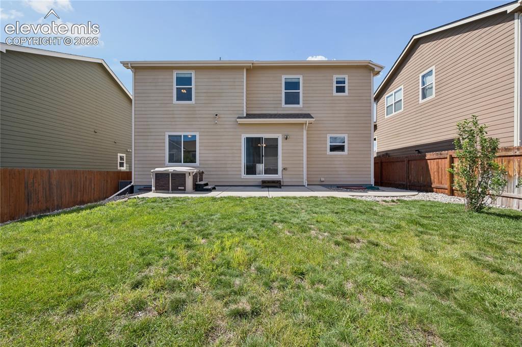 Image 19 of 20: Fenced backyard, and a hot tub, green grass