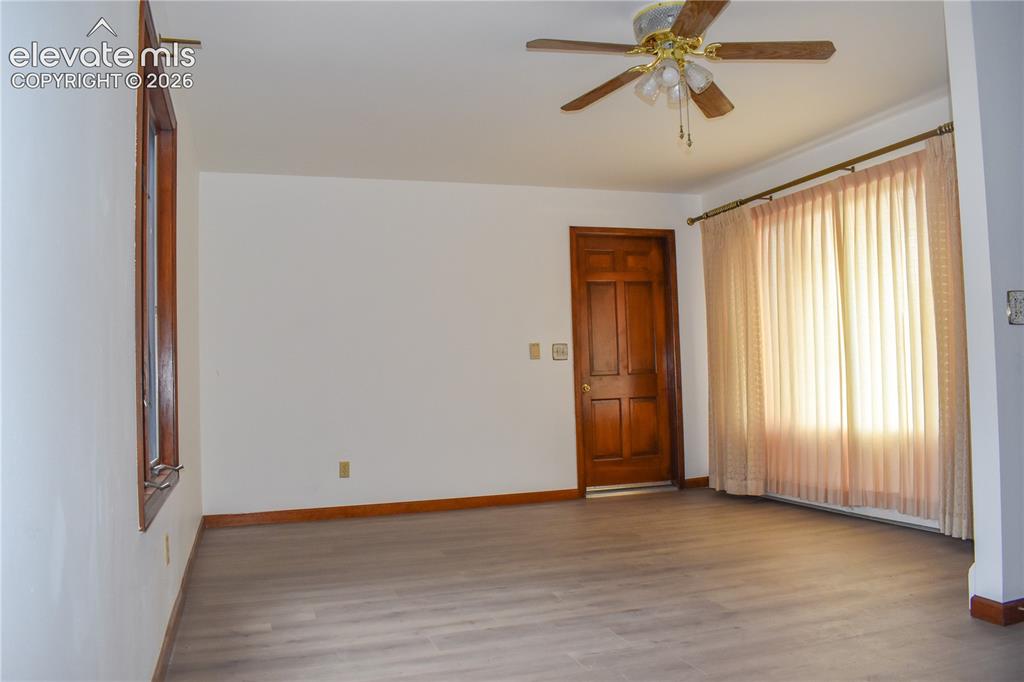 Image 11 of 44: Wood-finish flooring, white walls, and a paneled wood door