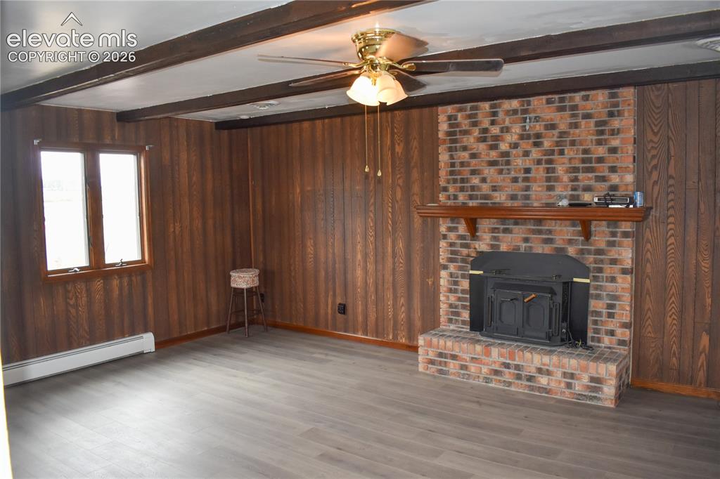 Image 13 of 44: Brick fireplace with a wood-burning insert and mantel