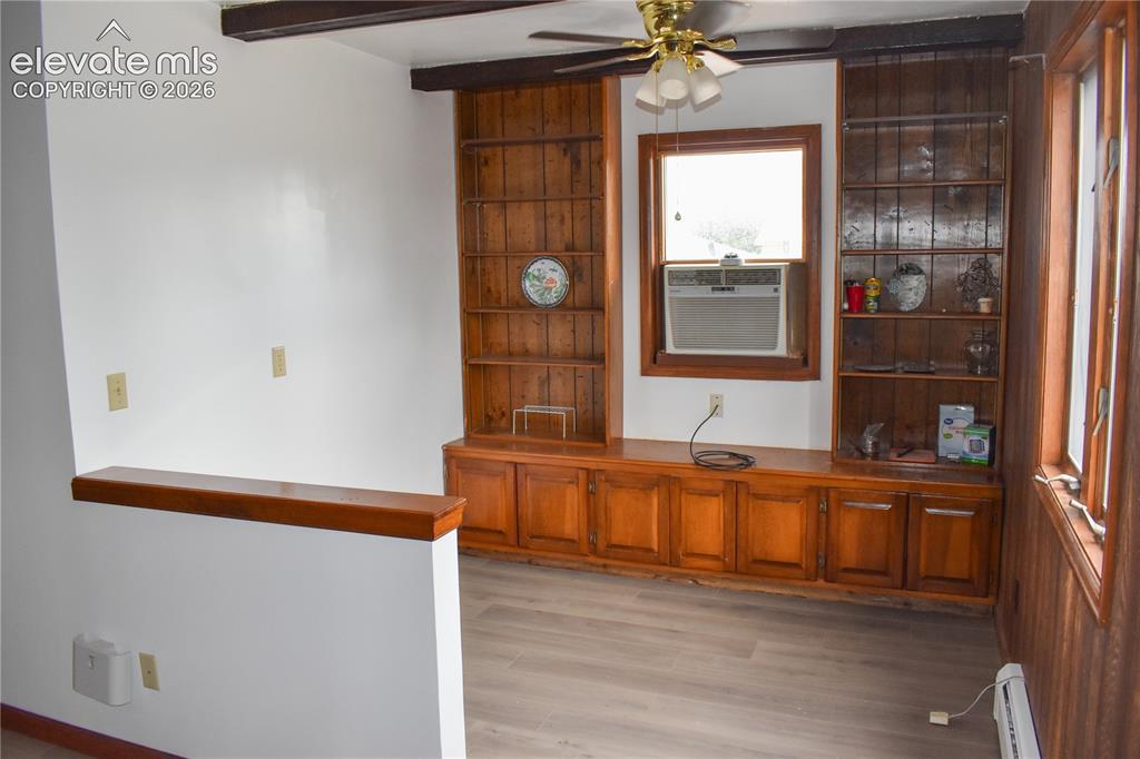 Image 16 of 44: Built-in wood cabinetry with shelving, wood-finish flooring, exposed ceilin