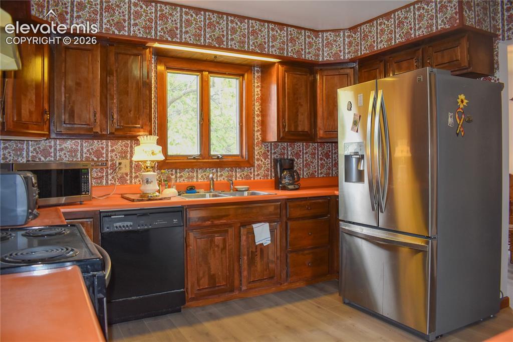 Image 20 of 44: Wood-finish cabinetry paired with orange countertops