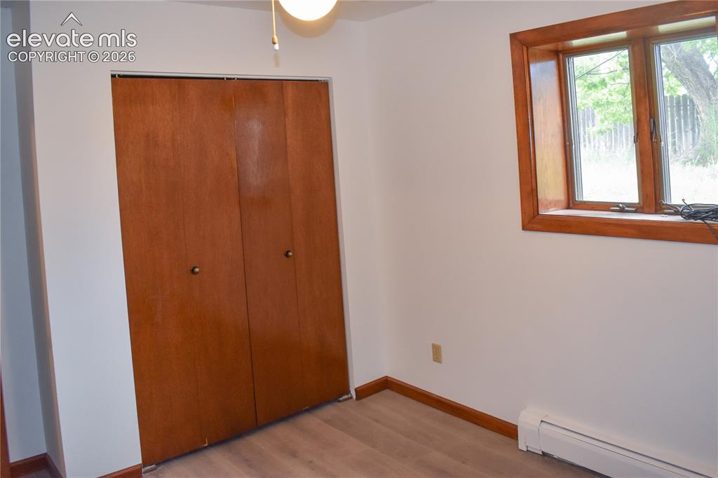 Image 26 of 44: Wood-finish flooring, white wall paint, natural wood trim window, and wood-