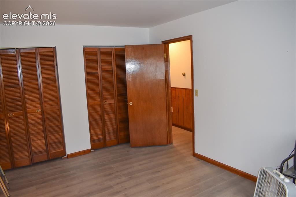 Image 28 of 44: Wood-finish flooring with white walls and wood trim
