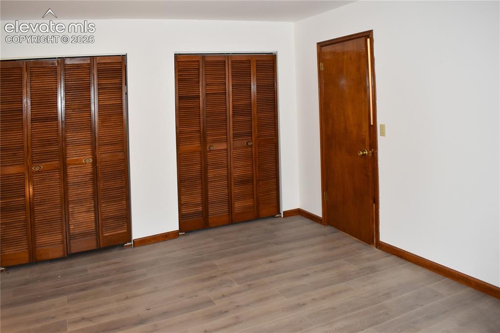 Image 29 of 44: Wood-finish flooring, white wall paint, two sets of louvered bi-fold closet