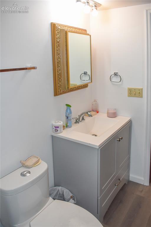 Image 40 of 44: Light gray vanity with an integrated sink and chrome faucet, featuring wood