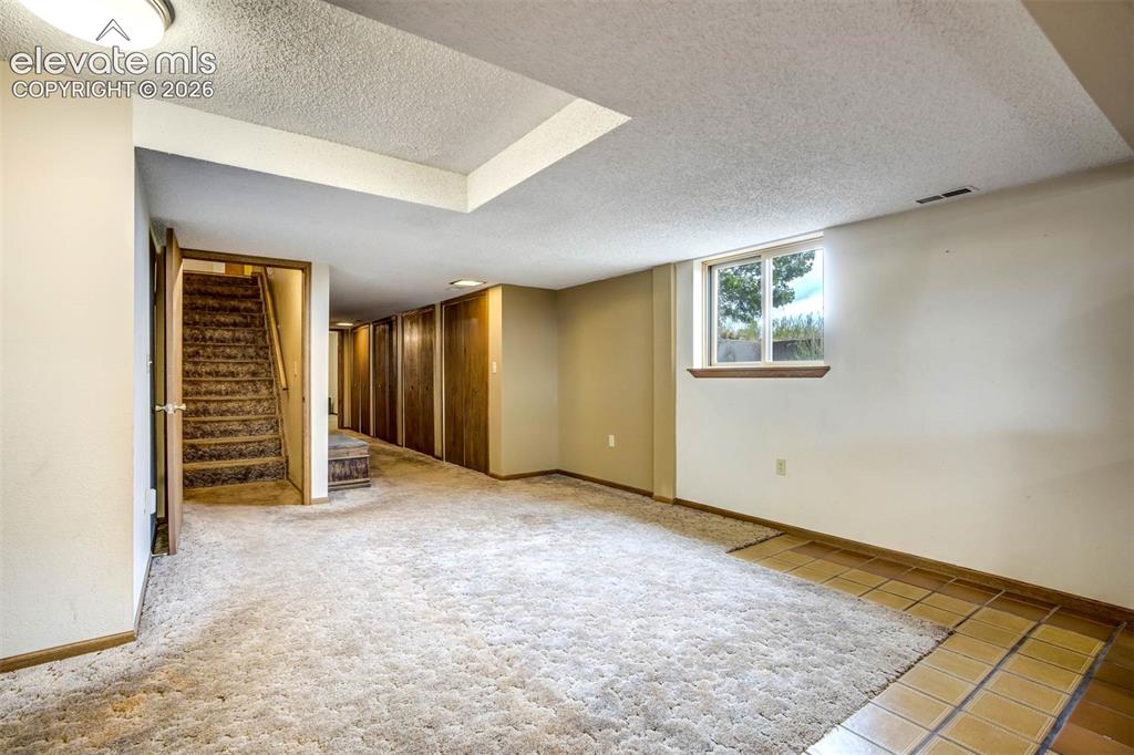 Image 27 of 48: stairway to family room, hall with multiple double closets, leads to 3/4 ba