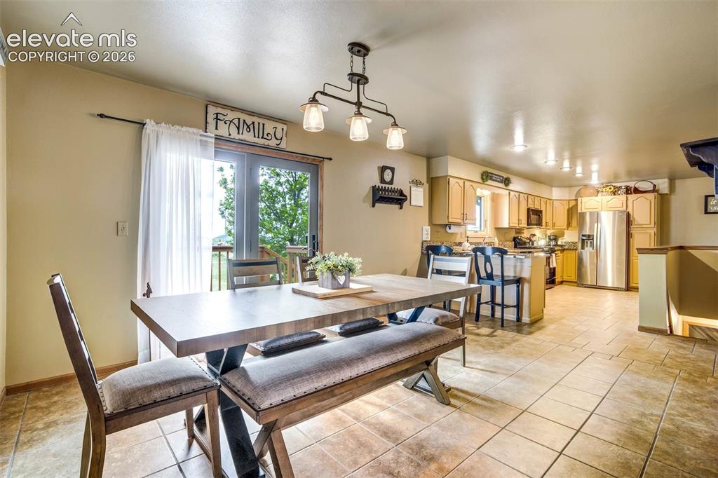 Image 9 of 48: Large dining kitchen space -walkout to deck faces east, tiled flooring
