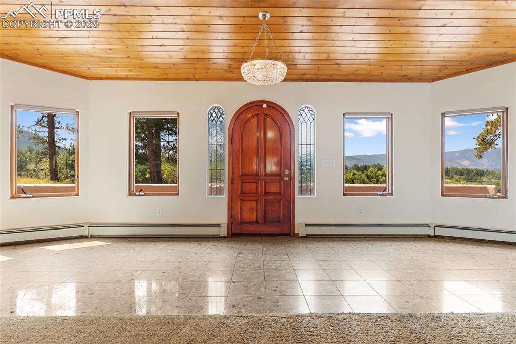 Image 20 of 50: Foyer entrance with wooden ceiling and baseboard heating