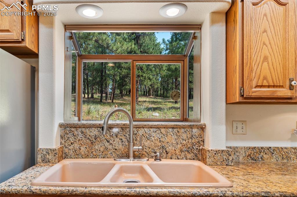 Image 26 of 50: Kitchen view of light countertops and freestanding refrigerator