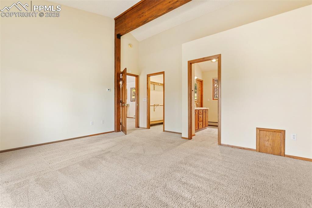 Image 39 of 50: Unfurnished room with beamed ceiling, light colored carpet, and high vaulte