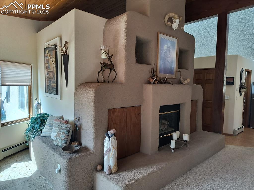 Image 5 of 50: Living area featuring a glass covered fireplace and a baseboard radiator