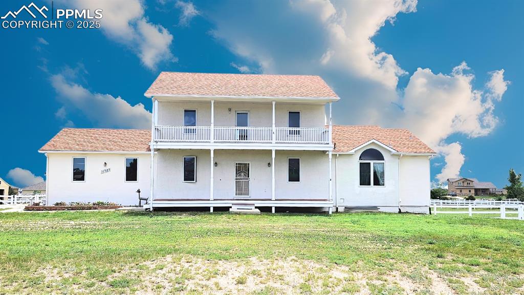 Caption: Large Home on 1 Acre of Land. Front of Home with a balcony and stucco.  Upgraded windows and (2) cov