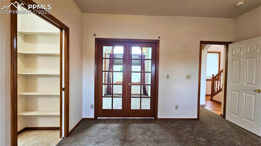 Image 13 of 28: Doorway featuring French doors, carpet flooring, and built in features