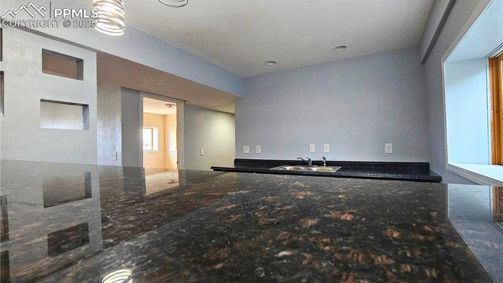 Image 23 of 28: Wet Bar with Solid Countertops, cabinets,  and pendant lighting