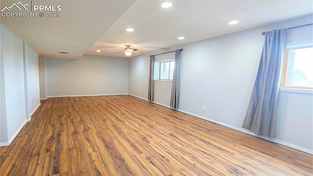 Image 25 of 28: Spare room with wood finished floors, ceiling fan, and recessed lighting