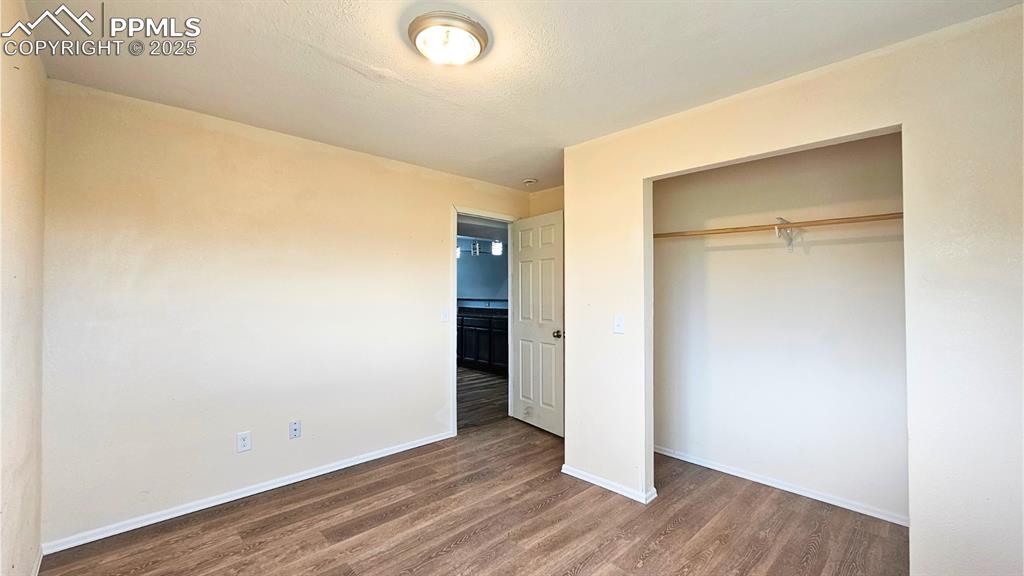 Image 26 of 28: Bedroom 5 - with wood finished floors and a closet