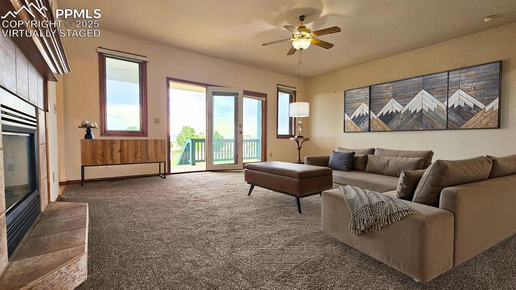 Image 9 of 28: VIRTUALLY STAGED Living room featuring a ceiling fan, carpet floors, and a 