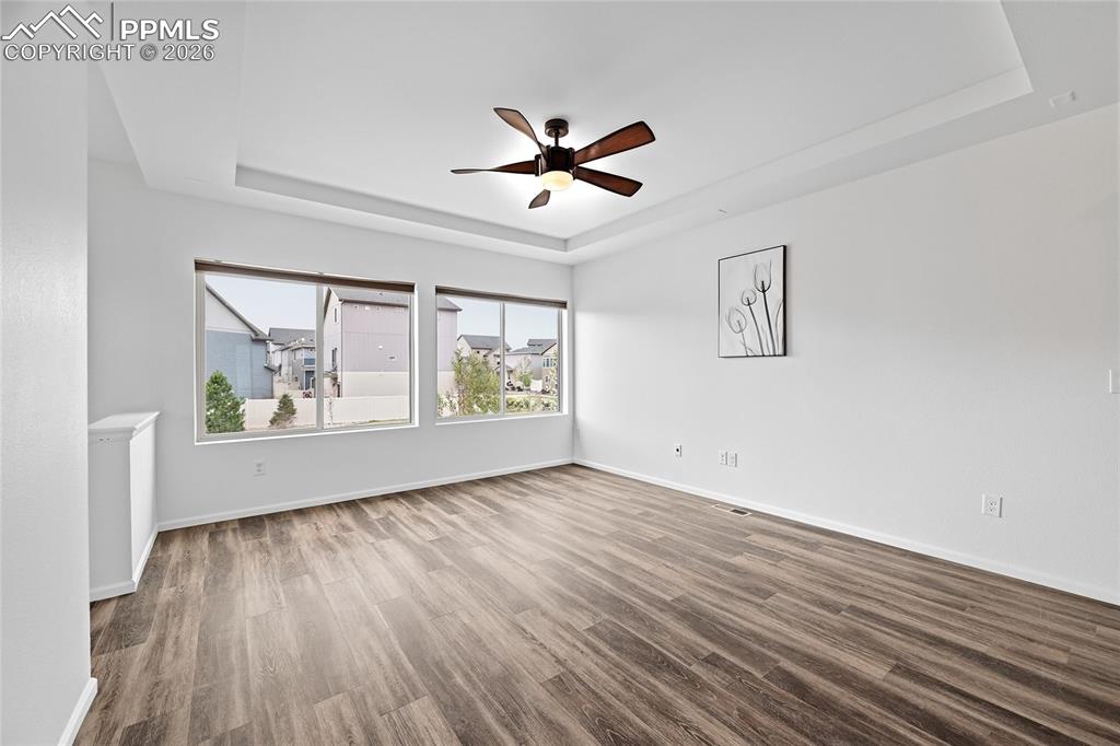 Image 10 of 40: Unfurnished living room featuring two big windows, a raised ceiling, a ceil