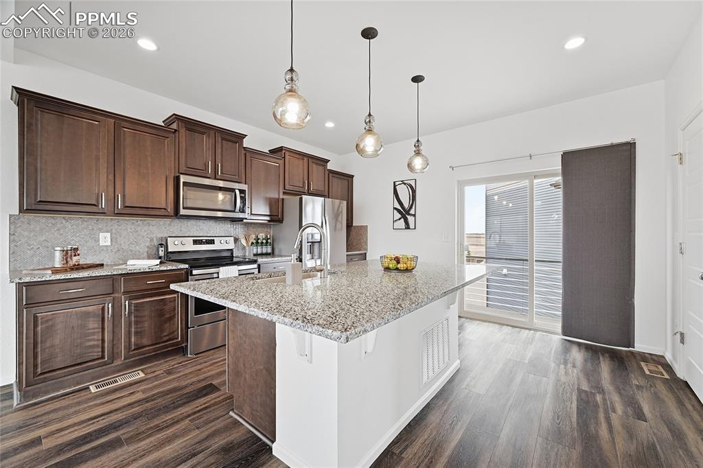 Image 12 of 40: Kitchen with light stone counters, stainless steel appliances, a kitchen is