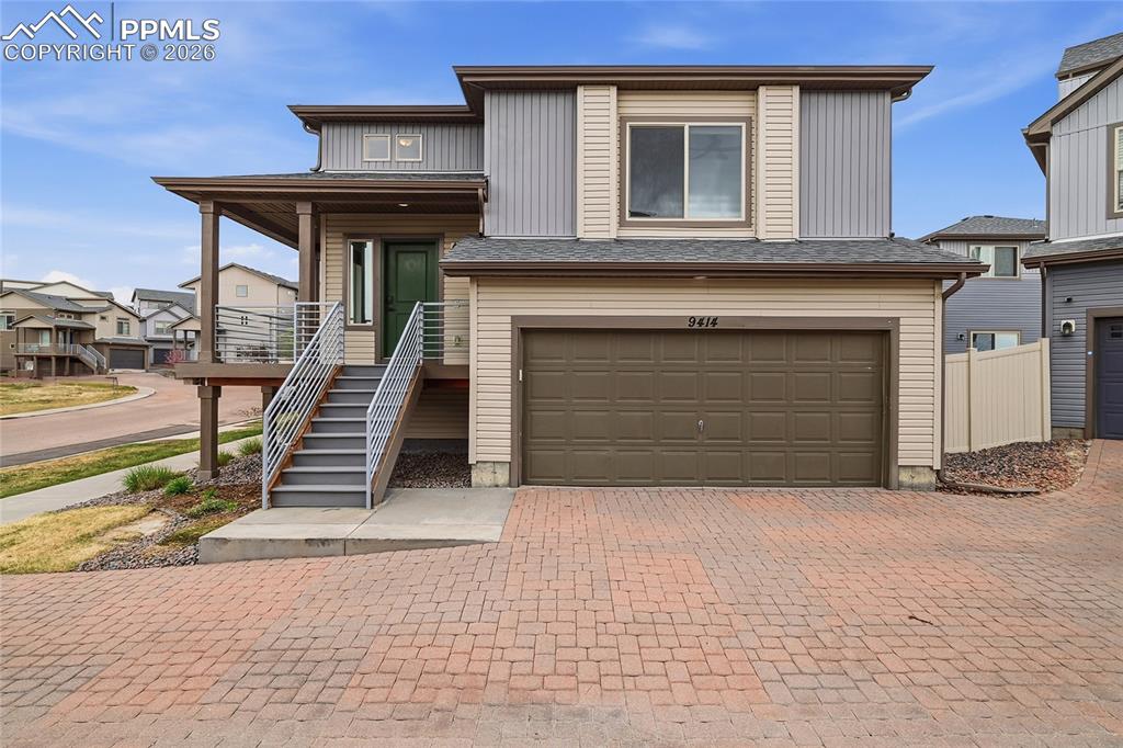 Image 2 of 40: View of front of property featuring a garage, decorative driveway, covered 