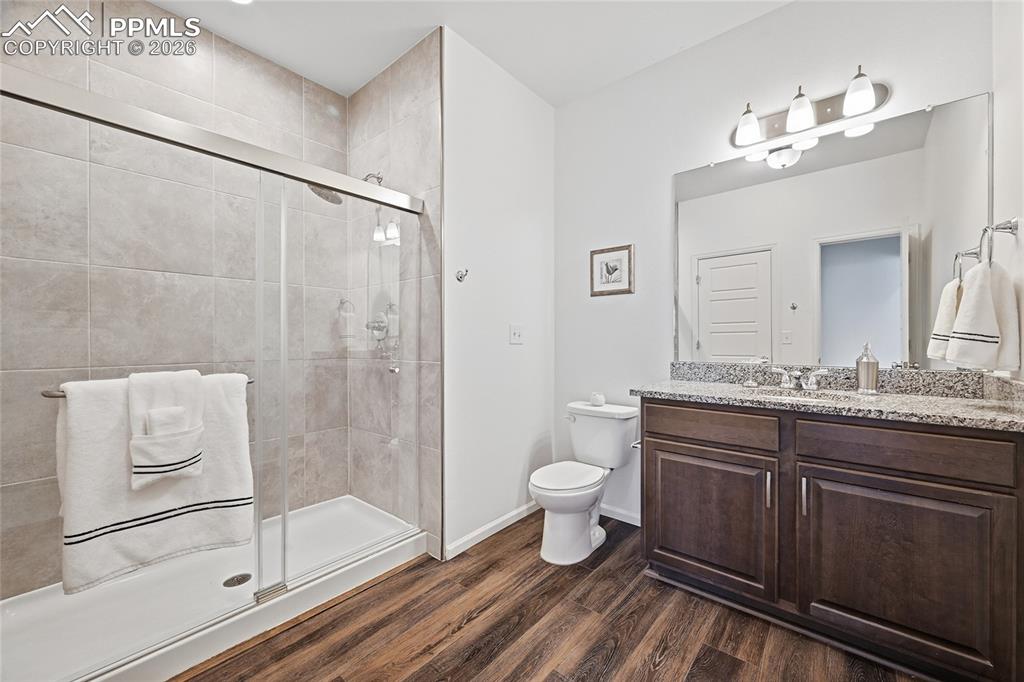 Image 20 of 40: Upper level bathroom, dark wood finish cabinetry, light stone countertops, 