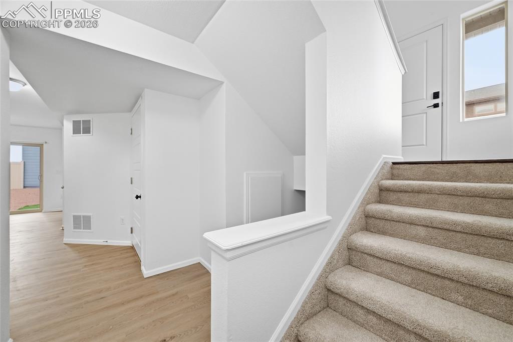 Image 22 of 40: Lower level stairs with light luxury vinyl wood-style floors