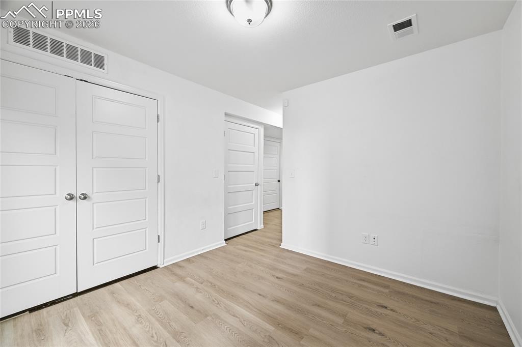 Image 27 of 40: Unfurnished lower-level bonus room with laundry closet, and light luxury vi