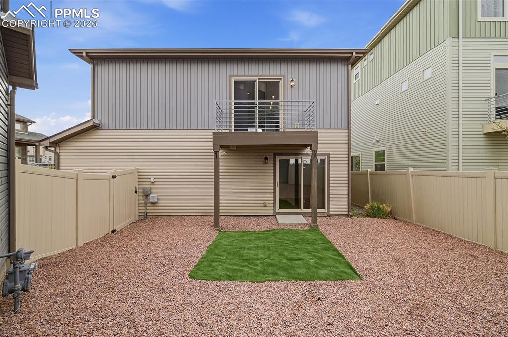 Image 30 of 40: Back of house featuring a balcony, a fenced backyard, and a patio area with