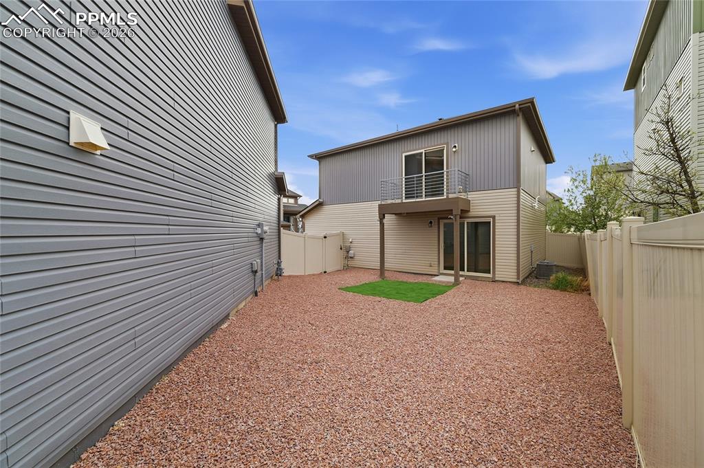 Image 31 of 40: Back of house featuring a balcony, a fenced backyard, and a patio area with